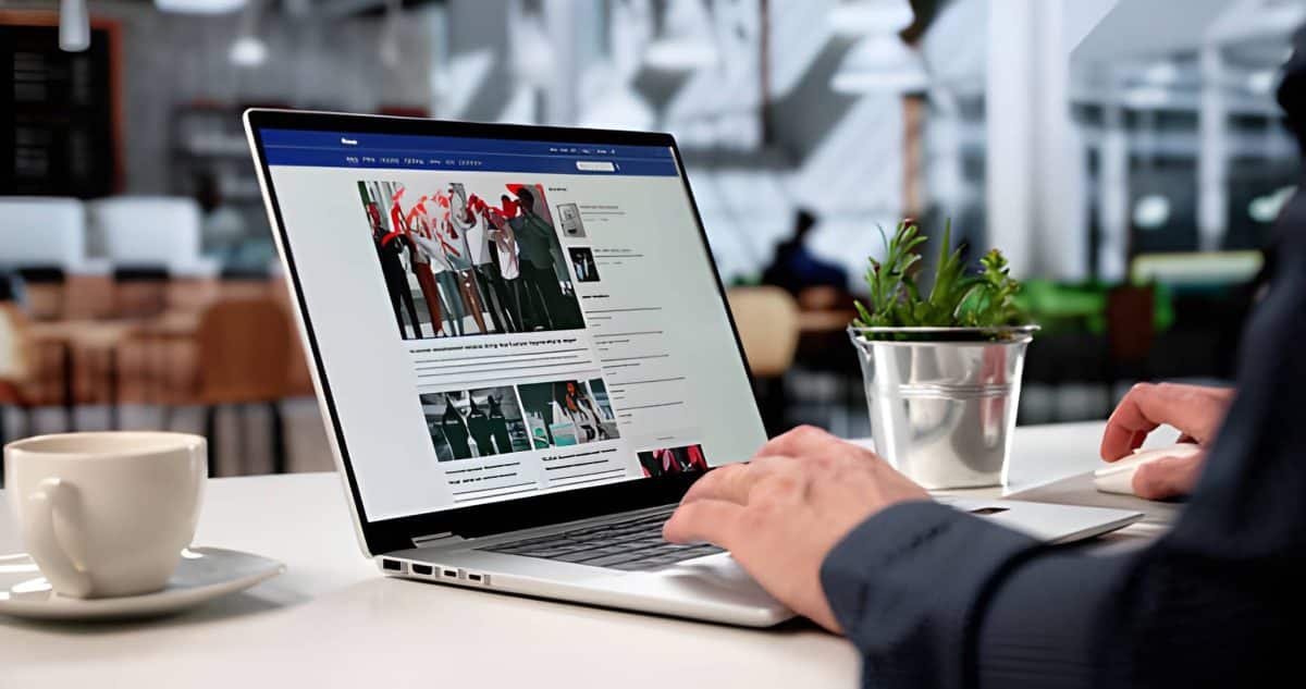 Joven periodista escribiendo artículo en una computadora portátil en un café