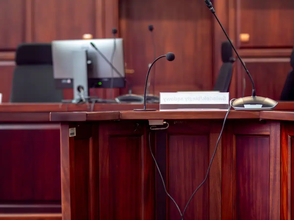 Sala de juzgado con equipos de grabaci&oacute;n y documentos judiciales.
