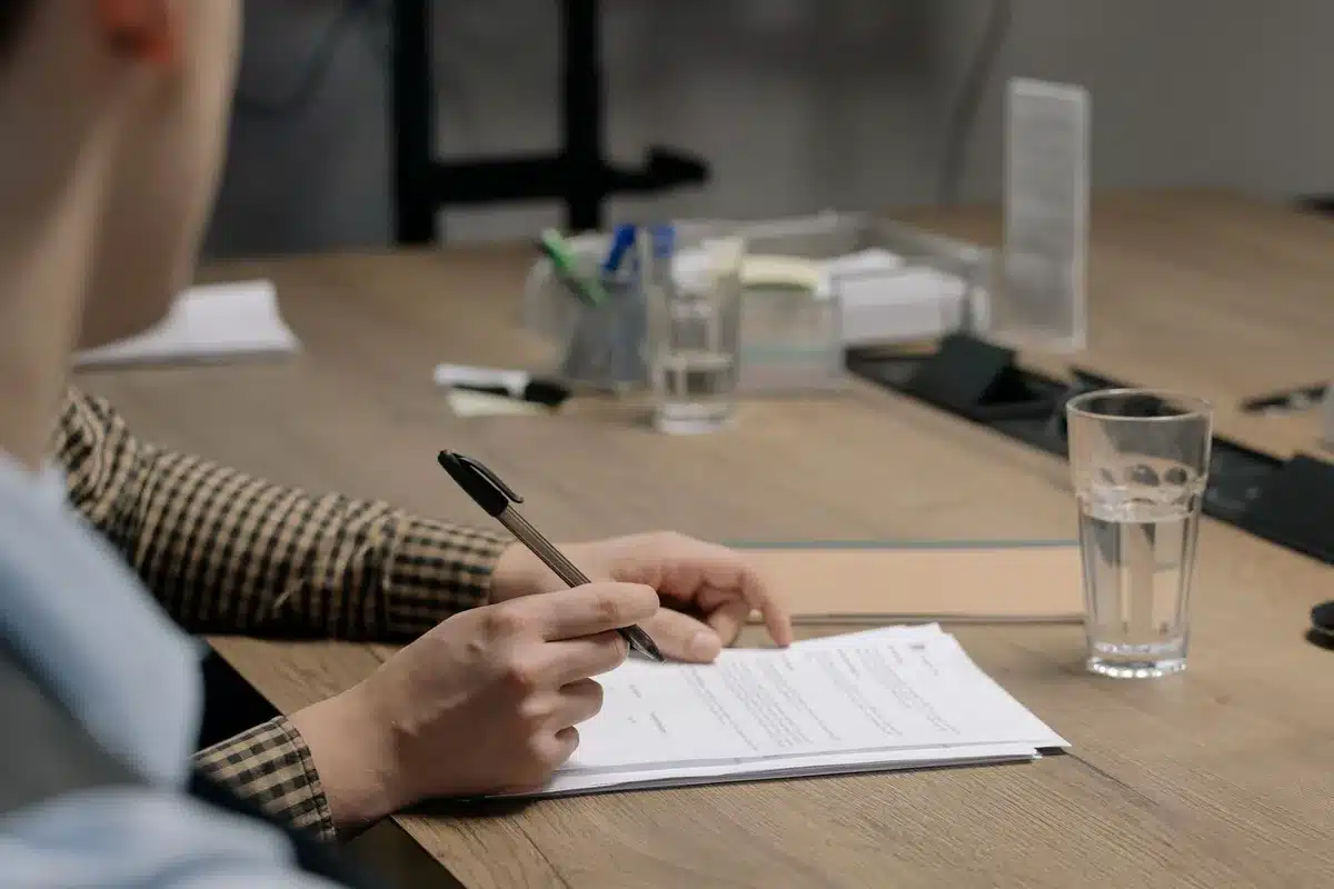 Documentos de contrato y firma en escritorio de oficina deportiva