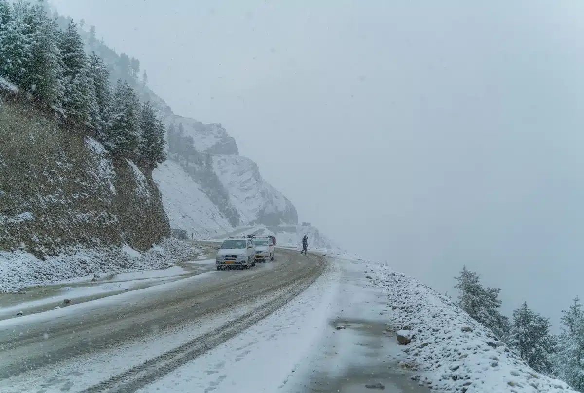 Carretera de montaña cubierta de nieve con señalización de cadenas obligatorias