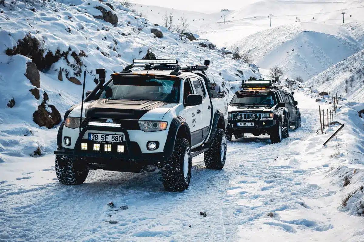 Fila de camiones varados en paso de montaña cubierto de nieve durante tormenta invernal