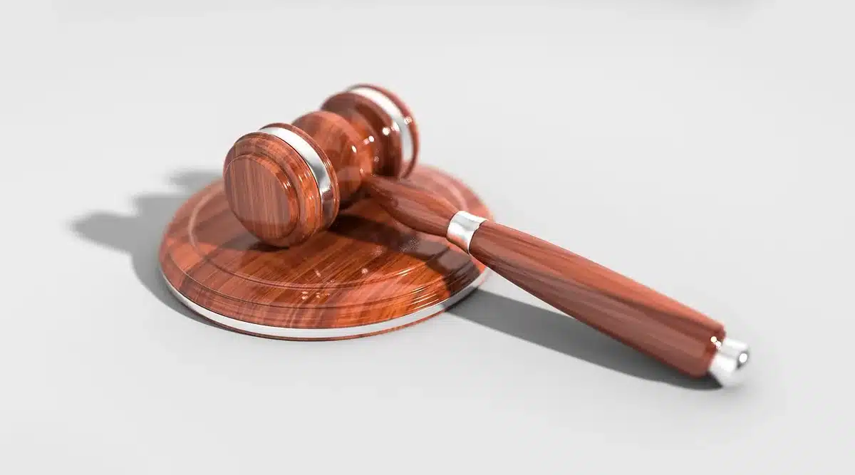 Juez y expedientes sobre un escritorio judicial en una sala de audiencias