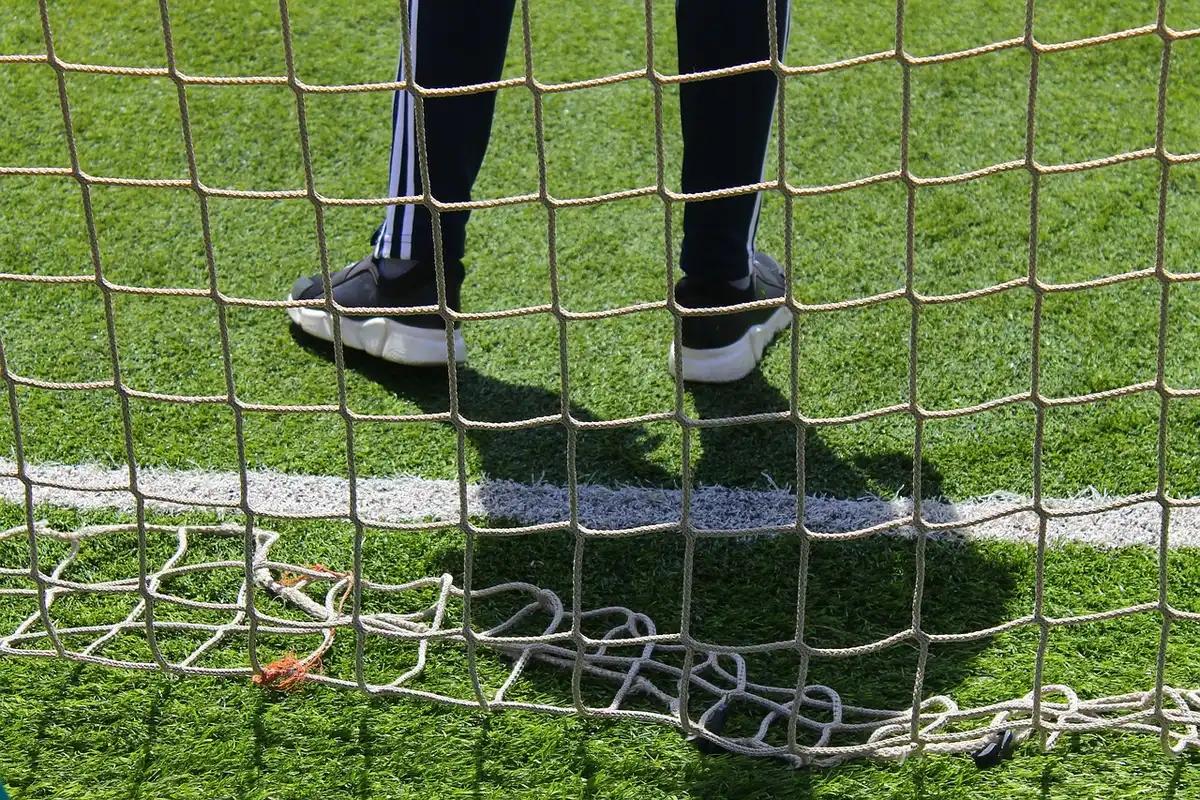 Portero lanzándose mientras un jugador patea desde el punto penal