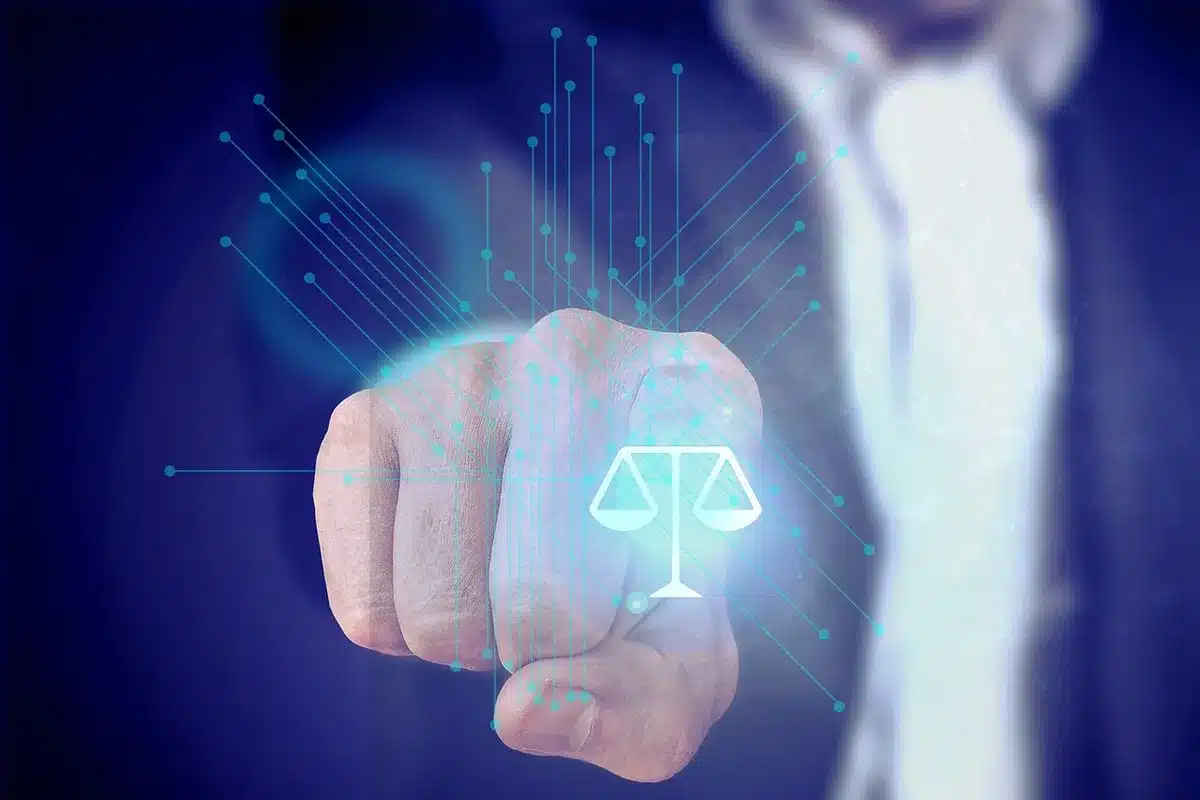 Persona revisando papeles legales junto a un teléfono y laptop