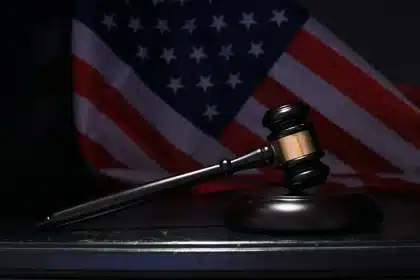 Manos intercambiando un cuadro enmarcado en una sala de justicia con documentos judiciales