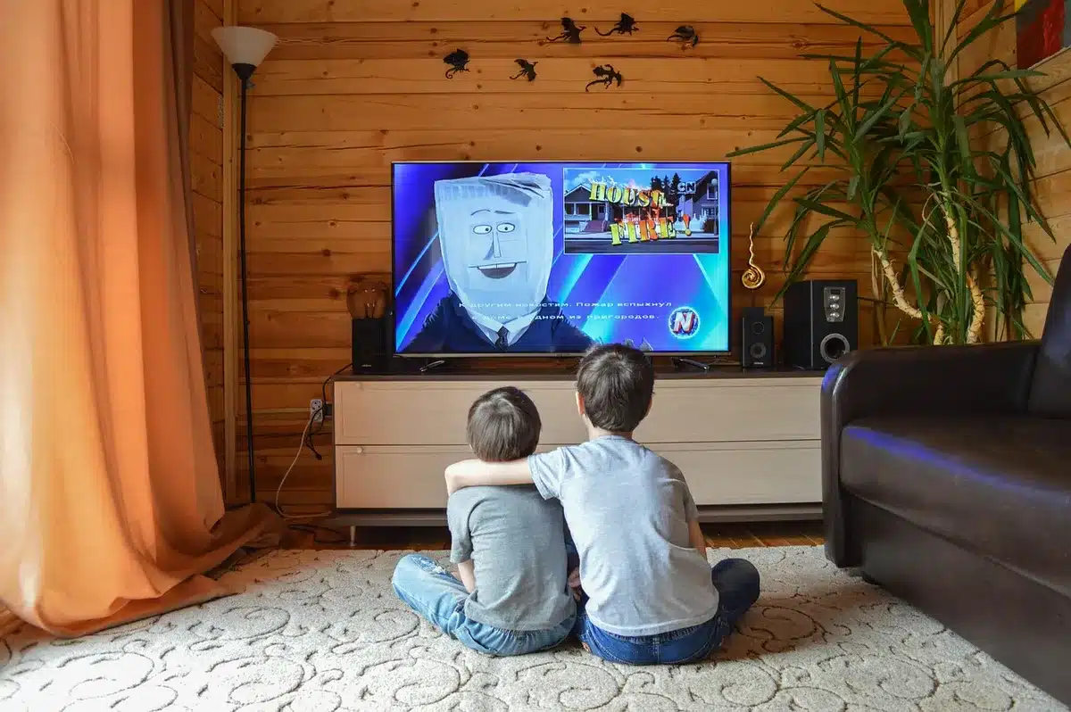 Paciente mayor viendo televisión desde su cama en la clínica