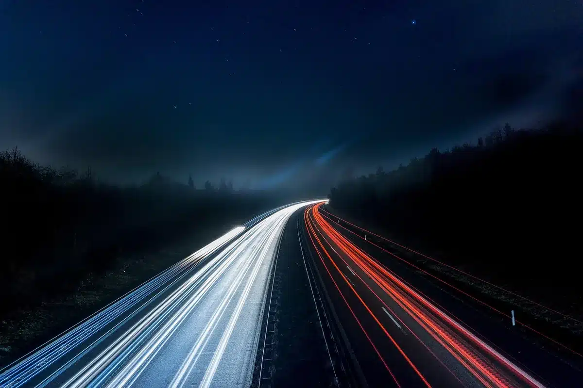Camiones de carga circulando de noche en ruta rural con marcas retrorreflectivas visibles