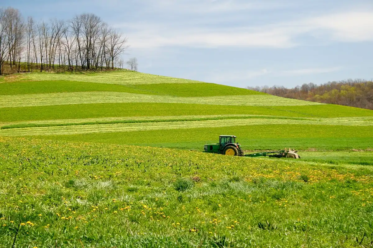 Campo agrícola seco con sistema de riego y tractor
