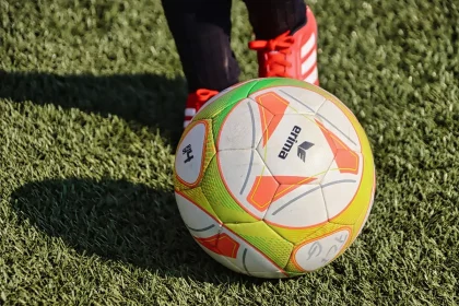 Two anonymous youth players warming up near cones and a goal on a club training ground