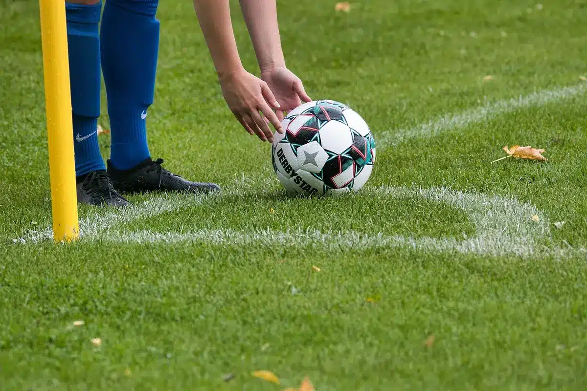 Silueta de mediocampista en un campo de entrenamiento tropical al atardecer