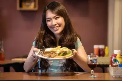 Manos sirviendo platos en una mesa de restaurante kosher moderno