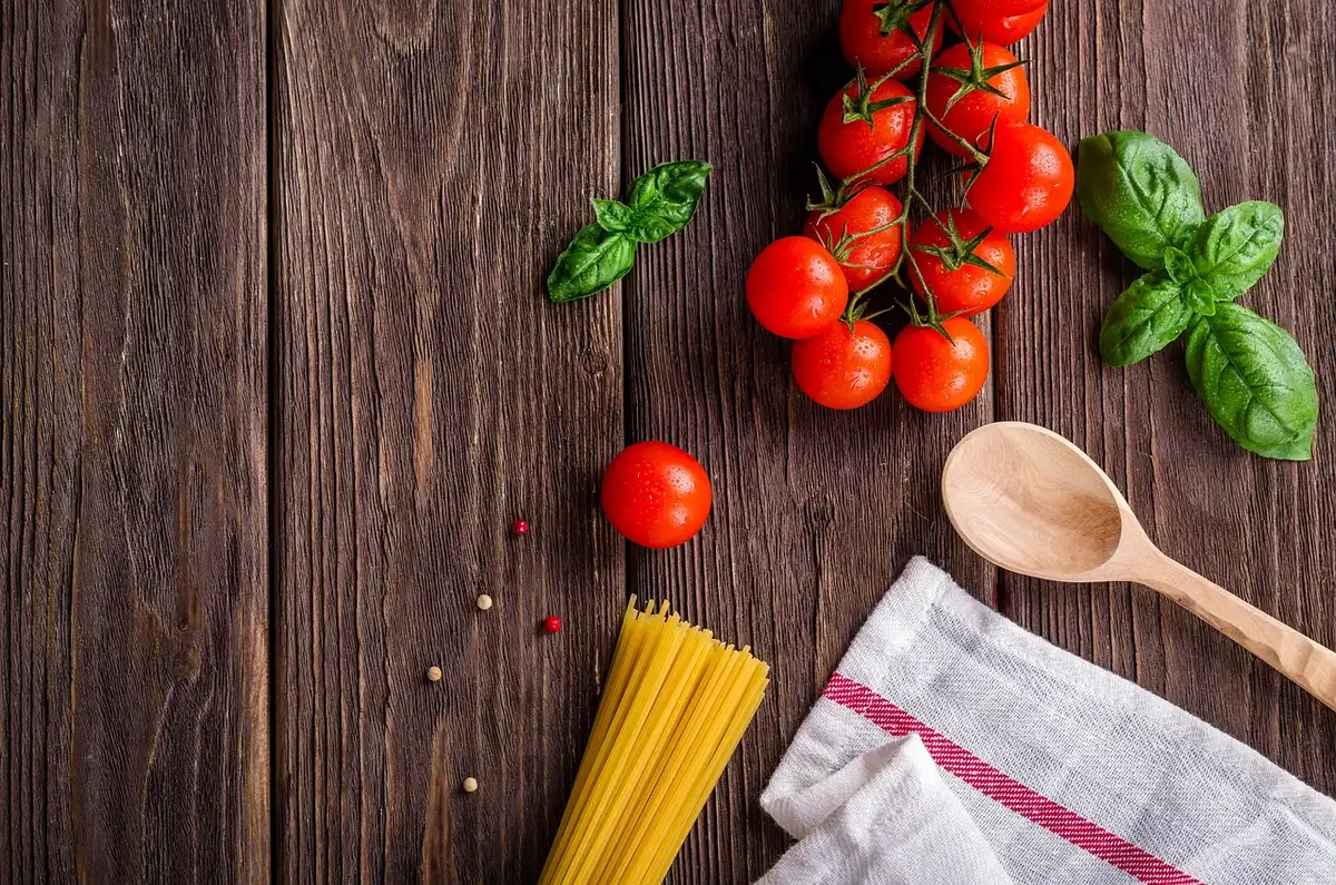 Cocina comunitaria con grandes ollas y cajas de alimentos listos para viandas