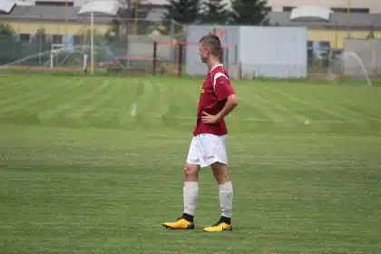 Silencio en la tribuna y un jugador en silueta celebrando junto al costado del campo
