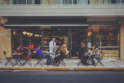 Silhouette de una pareja caminando cerca de un café en una calle de Madrid con maleta