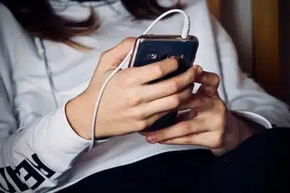 Manos sosteniendo teléfonos plegables genéricos en una mesa de tienda