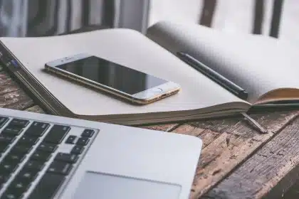 Manos anónimas hojeando una revista de economía sobre una mesa con notas
