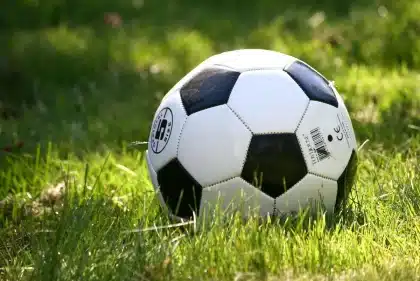 banquillo vacío junto a una pelota en la banda del estadio
